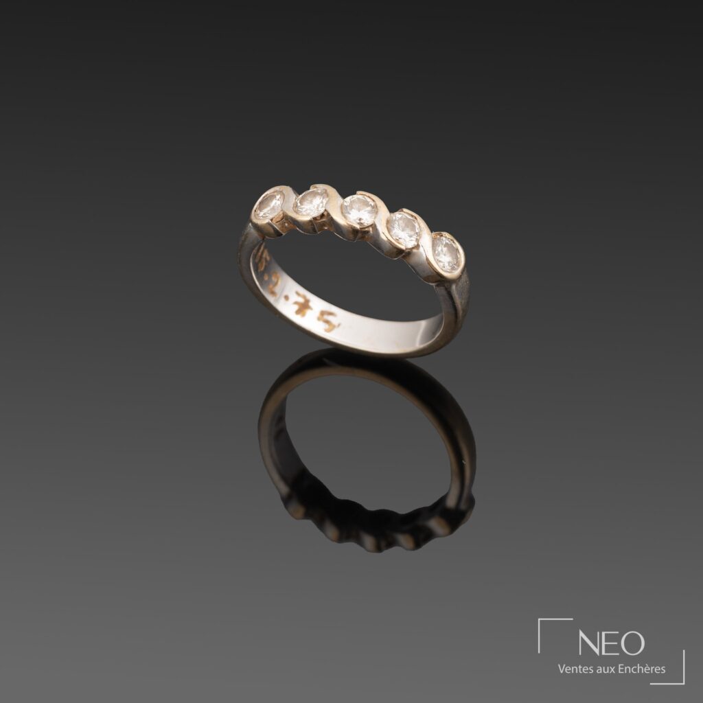Demi-alliance en or blanc sertie de cinq brillants sur fond noir