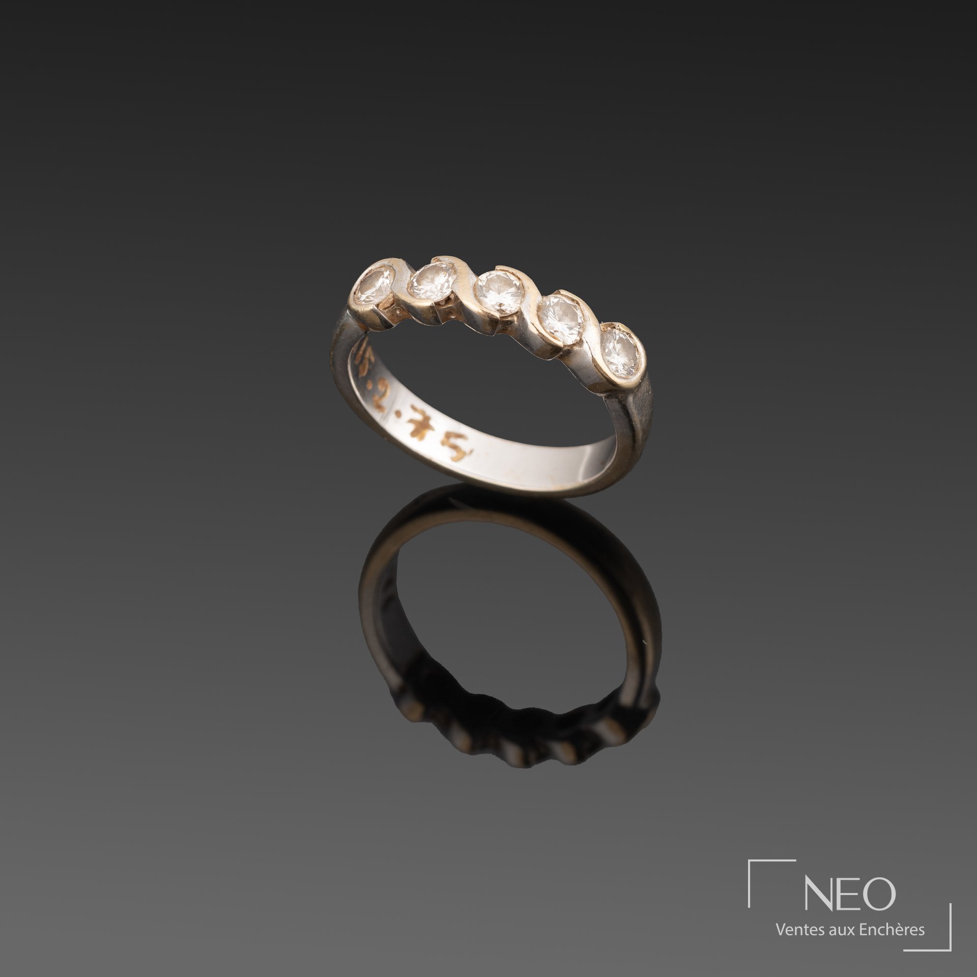 Demi-alliance en or blanc sertie de cinq brillants sur fond noir