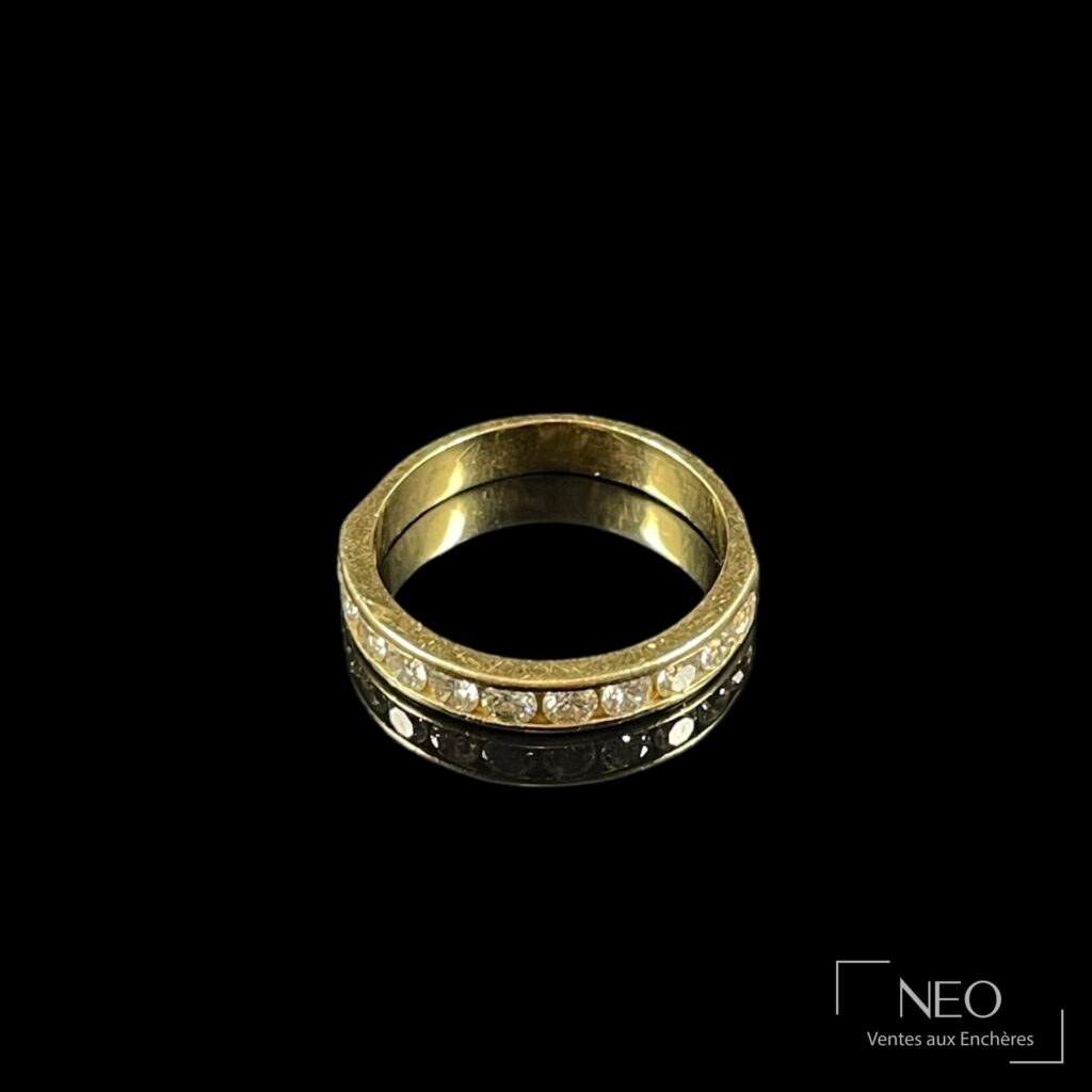 Demi-alliance en or jaune sertie d’une rangée de diamants sur fond noir