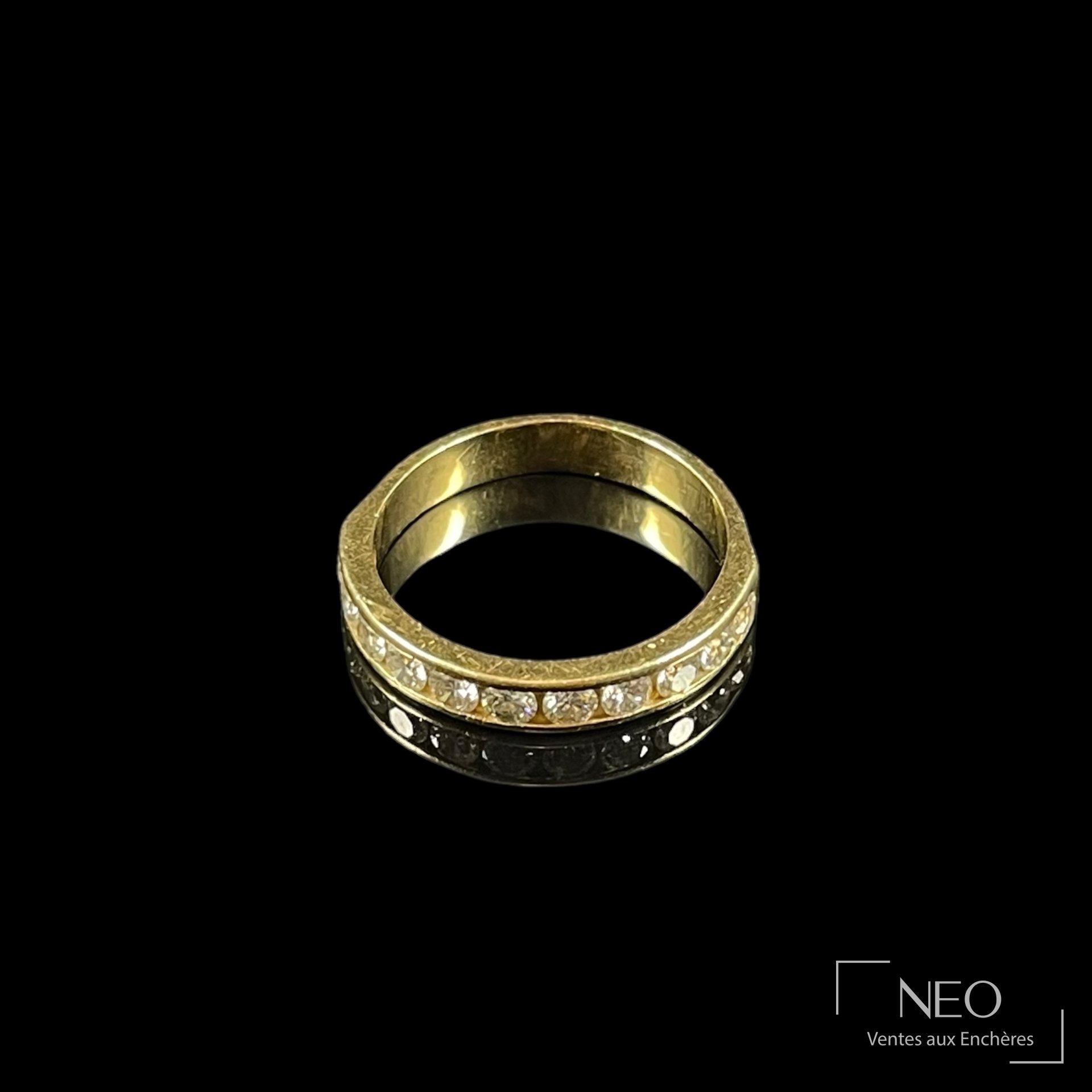 Demi-alliance en or jaune sertie d’une rangée de diamants sur fond noir