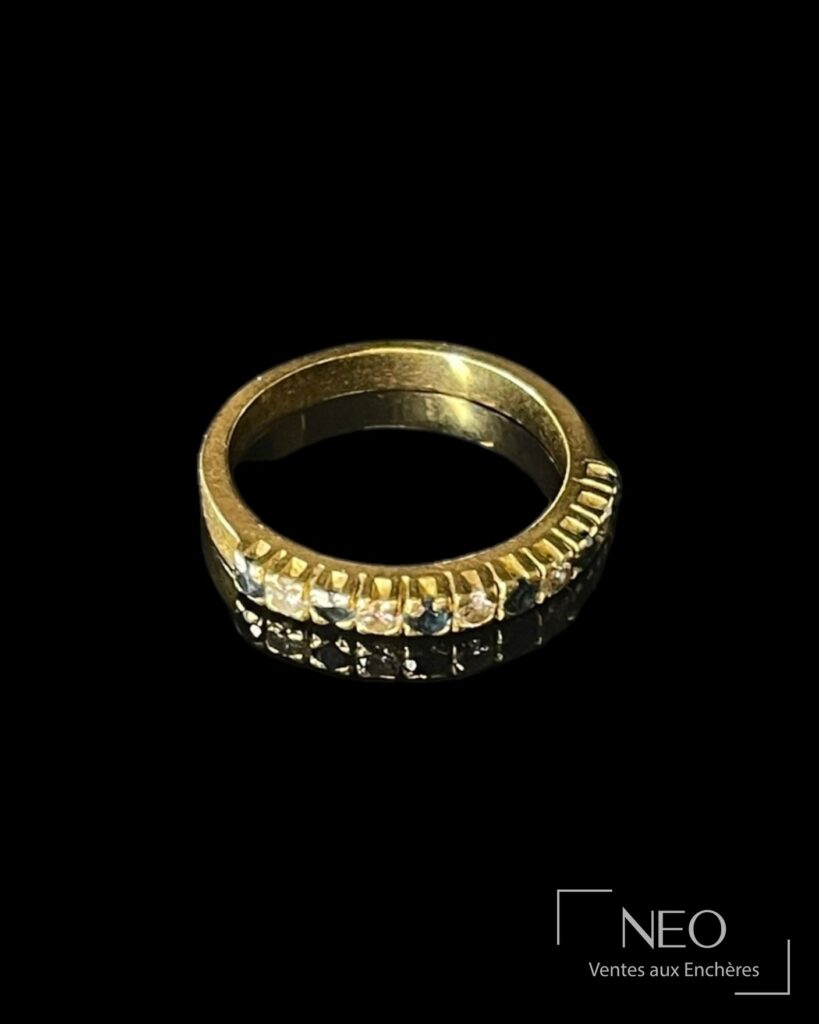 Demi-alliance en or jaune sertie de saphirs et diamants sur fond noir