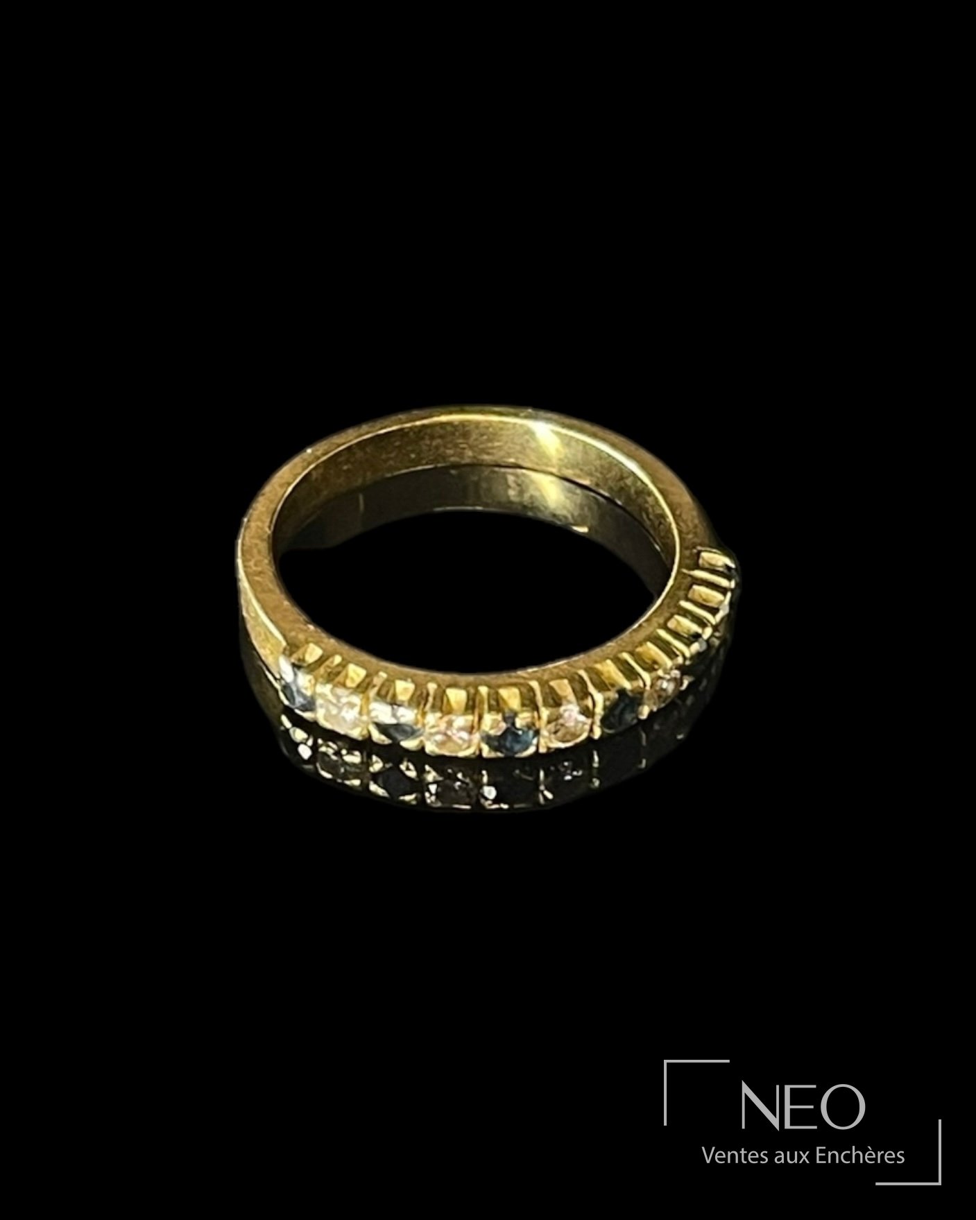 Demi-alliance en or jaune sertie de saphirs et diamants sur fond noir