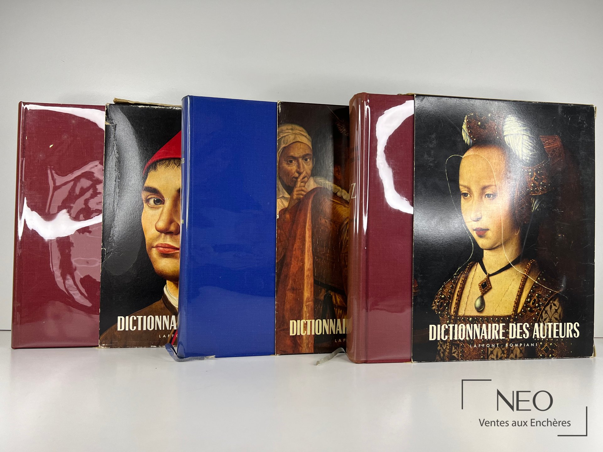 Trois volumes et leurs coffrets illustrés rangés de face.