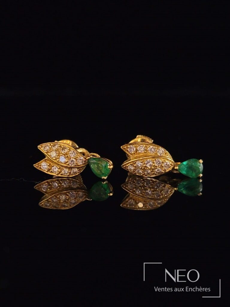 Paire de dormeuses en or jaune avec diamants et émeraudes sur fond noir