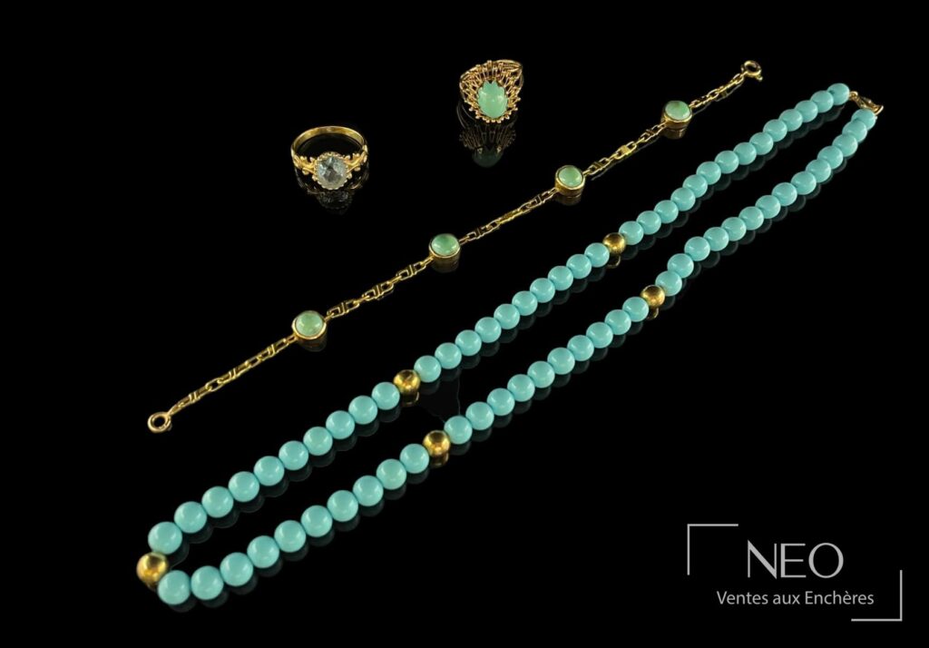 Ensemble de bijoux en or jaune et pierres turquoise présenté sur fond noir