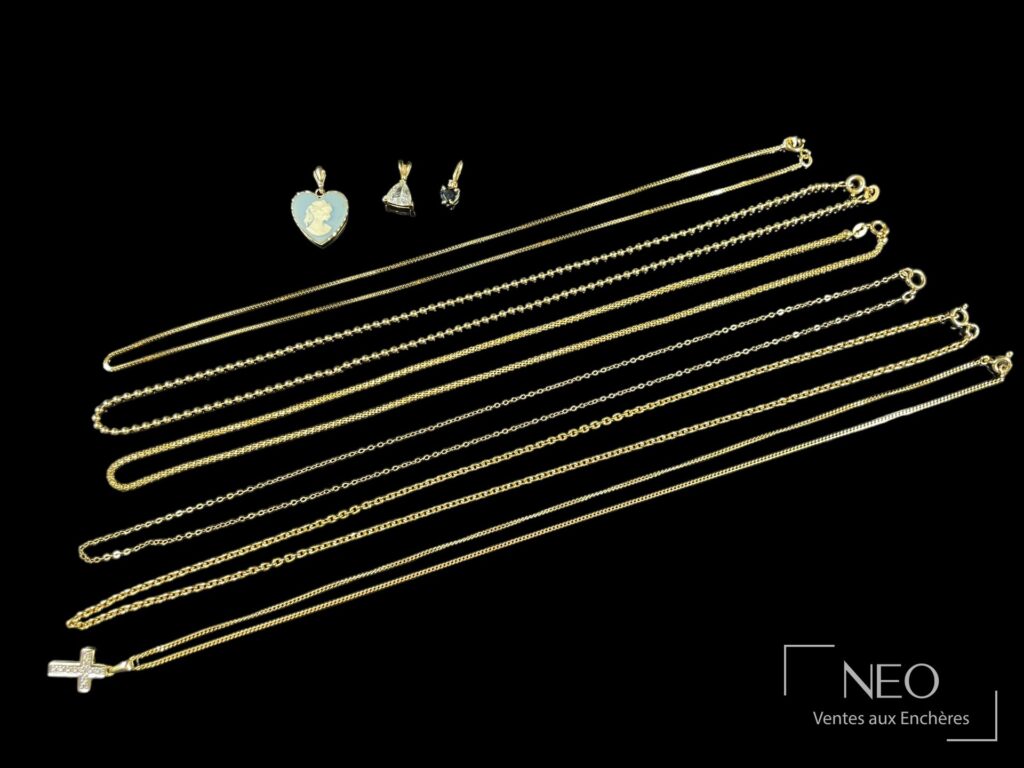 Ensemble de six chaînes en or jaune et quatre pendentifs sur fond noir