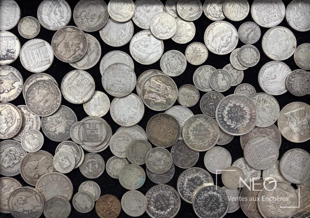 Ensemble de monnaies en argent mêlant pièces françaises et suisses sur fond noir