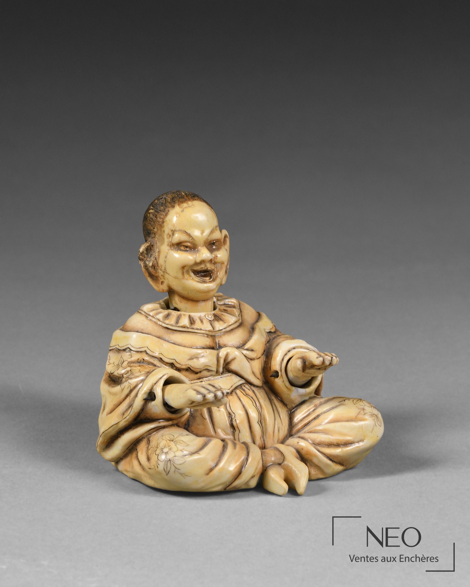 Figurine en porcelaine d'un homme moqueur assis