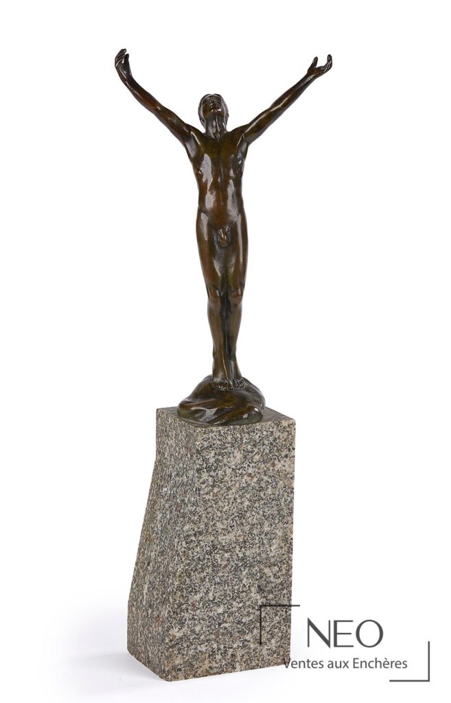 Bronze à patine verte représentant une figure nue les bras levés sur un socle en pierre