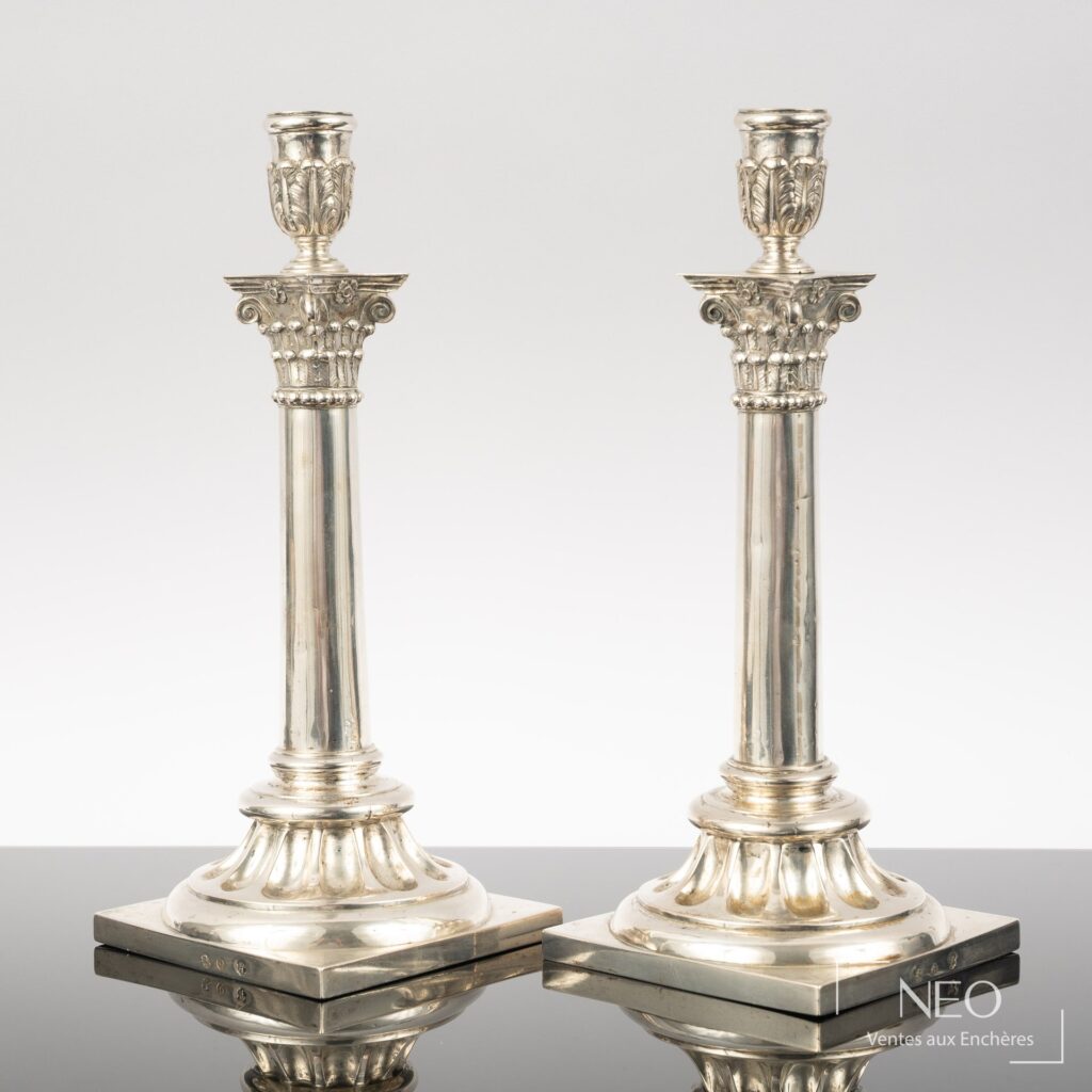 Paire de flambeaux en argent à bases carrées et fûts à décor corinthien