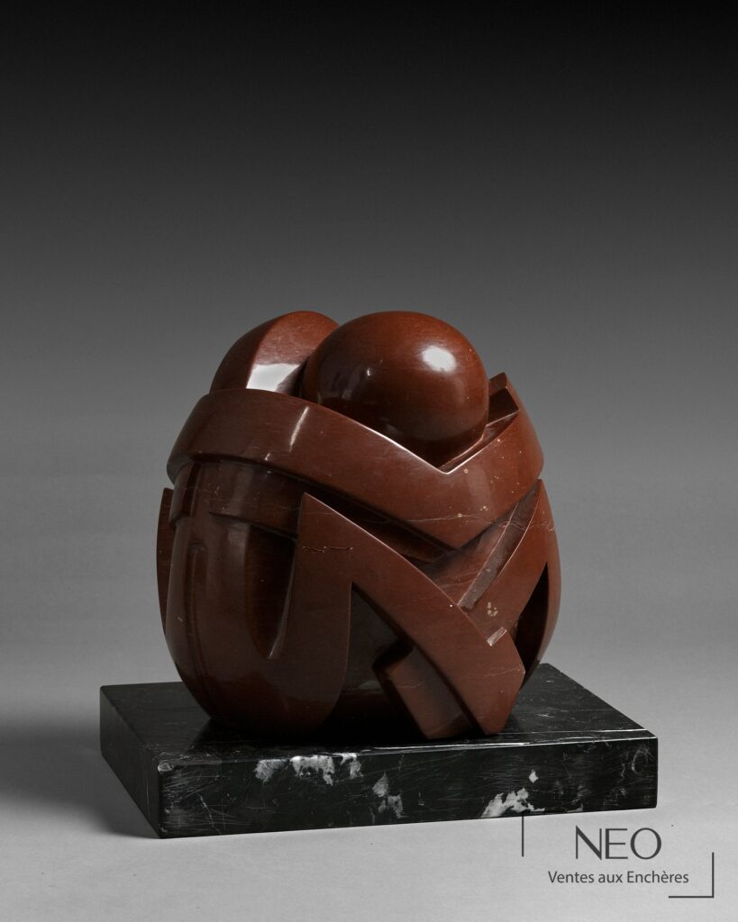 Sculpture abstraite en porphyre rouge posée sur un socle en marbre noir veiné blanc