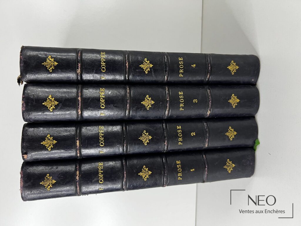 Quatre dos de volumes en demi basane bleue avec titres et fleurons dorés