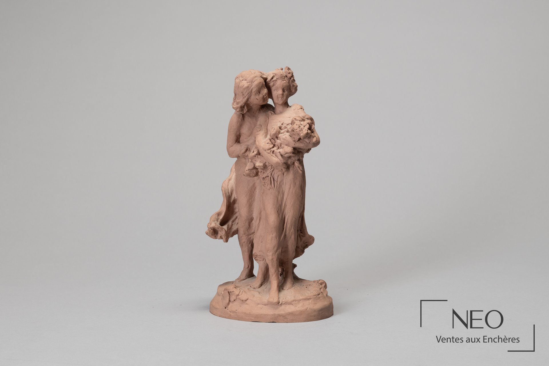Épreuve en terre cuite représentant deux figures féminines enlacées tenant des fleurs