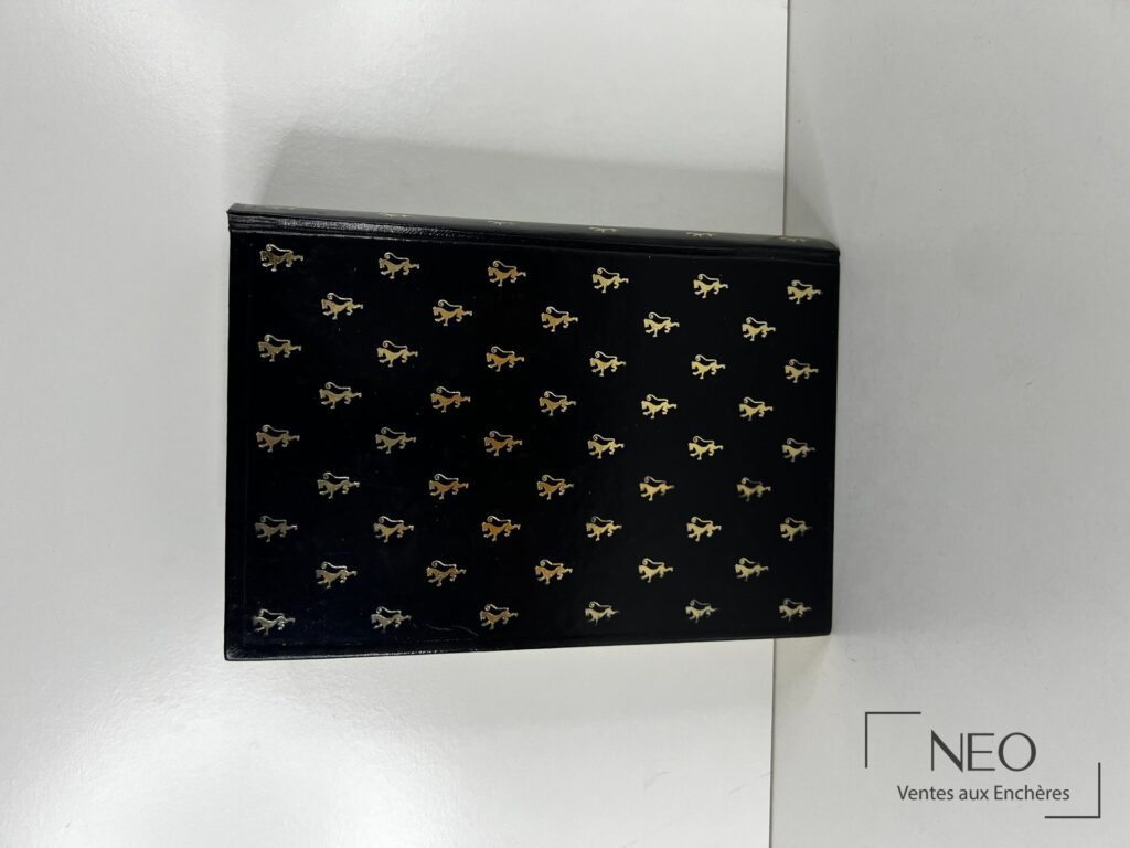 Couverture noire ornée de petits motifs dorés répétés