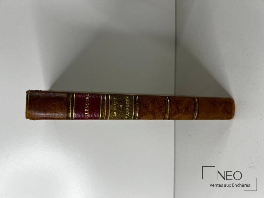 Dos d'un livre en demi basane avec titre doré sur pièce de maroquin rouge et jaune