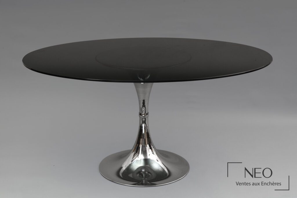 Table ovale en verre fumé avec piètement central tulipe en métal chromé