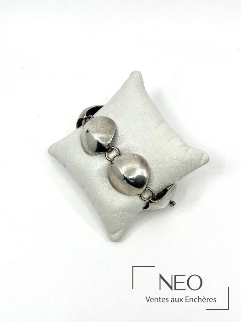 Bracelet en argent à cinq maillons stylisés sur coussin blanc
