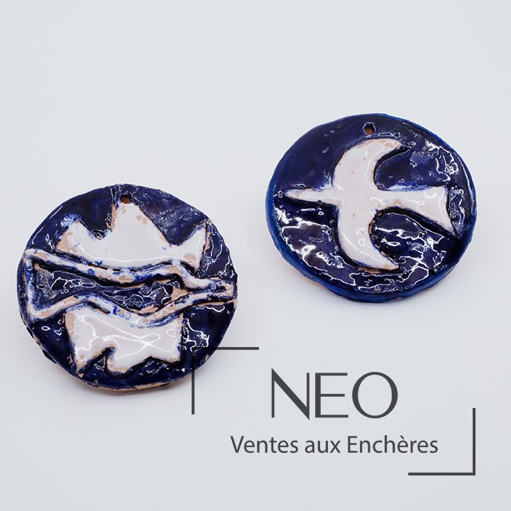 Deux pendentifs ronds en céramique émaillée bleue et blanche à décor d’oiseau