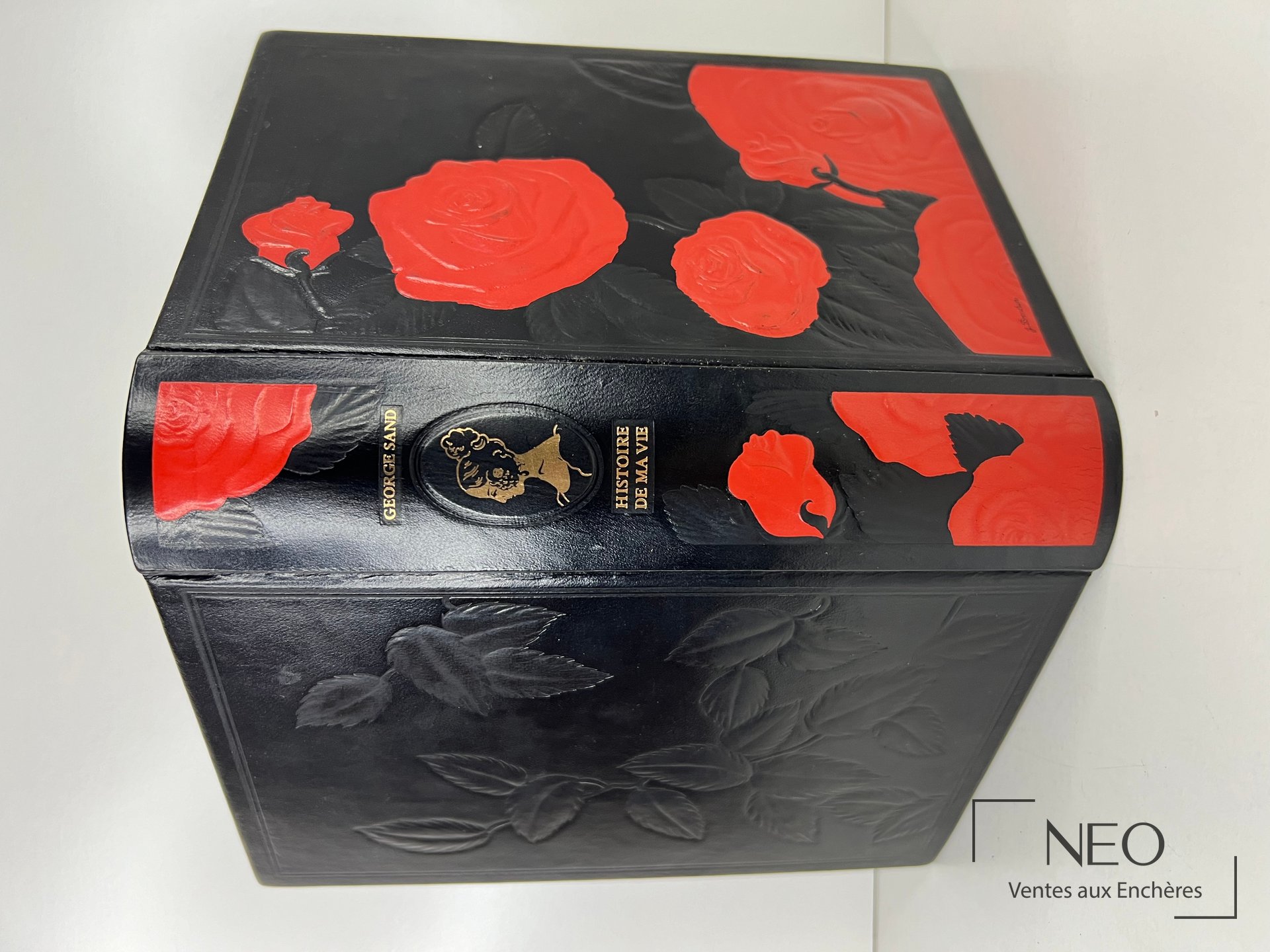 Livre relié noir aux roses rouges et aux titres dorés sur le dos