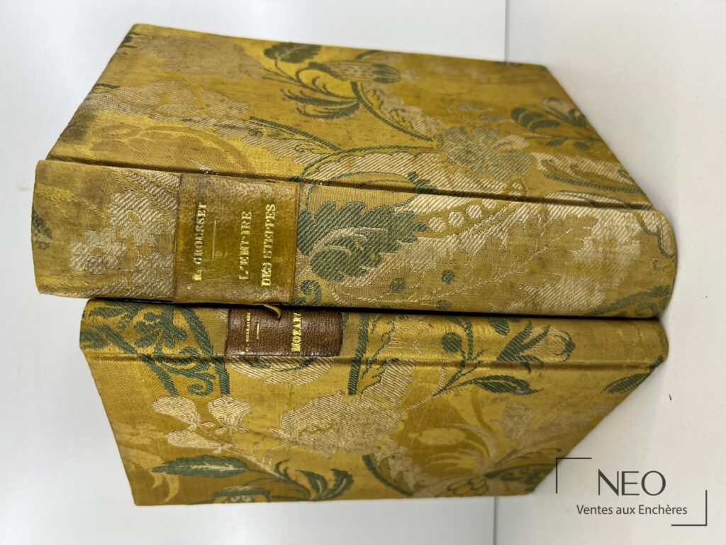 Deux ouvrages reliés en tissu fleuri doré