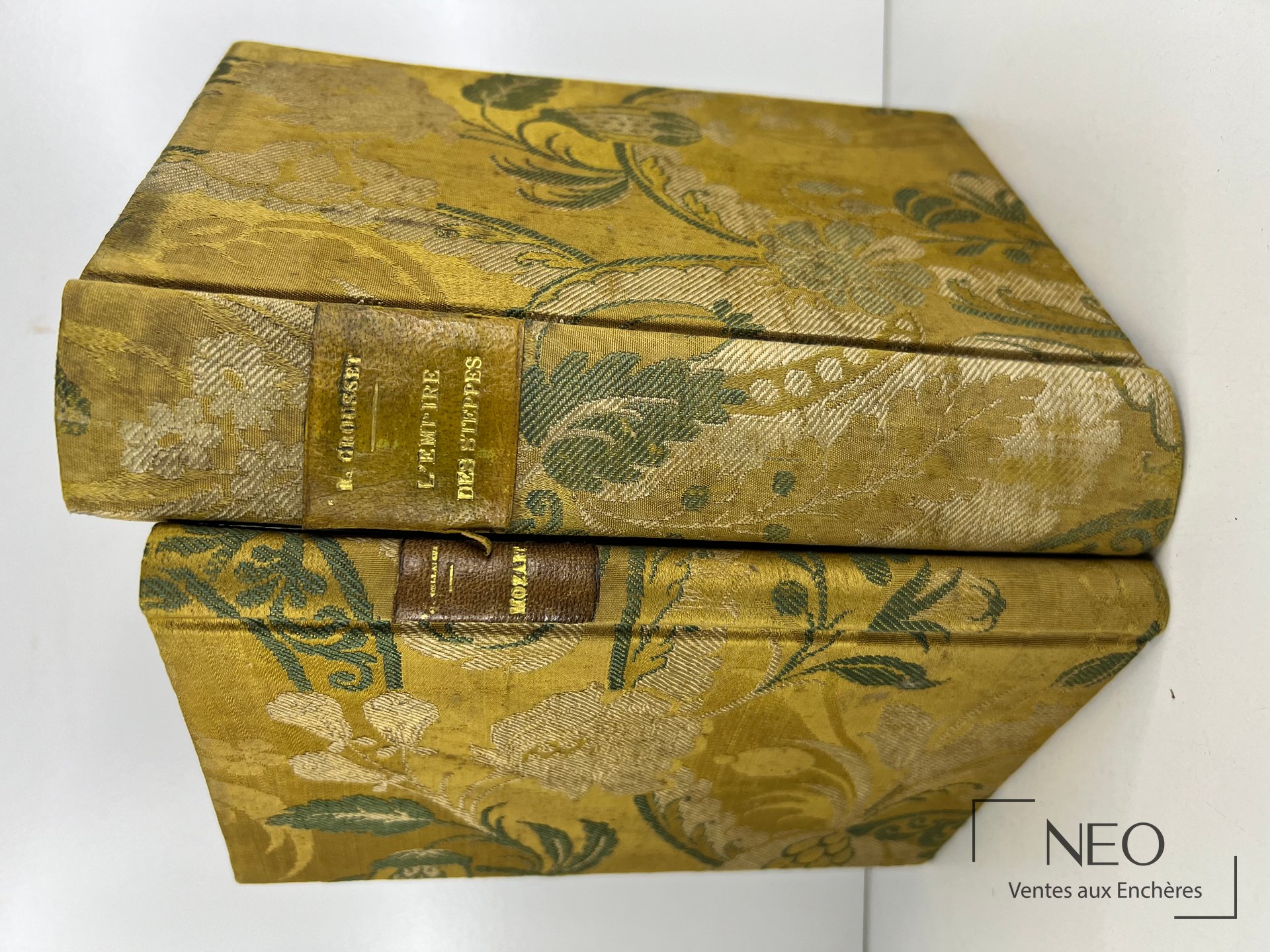 Deux ouvrages reliés en tissu fleuri doré