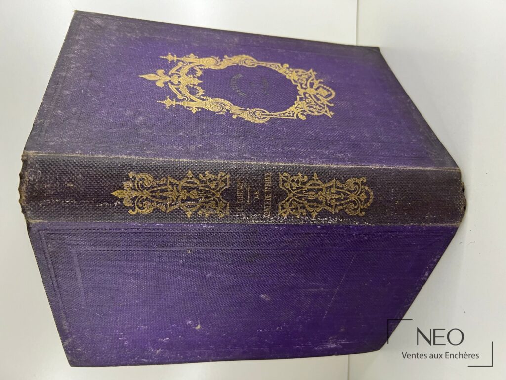 Couverture violette ornée de dorures sur le premier plat d’un livre ancien
