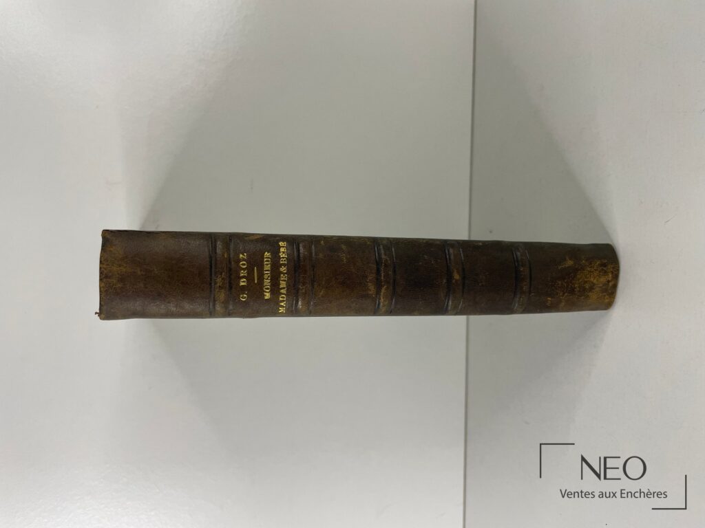 Dos d'un livre relié en demi chagrin brun avec titres dorés et nerfs apparents.
