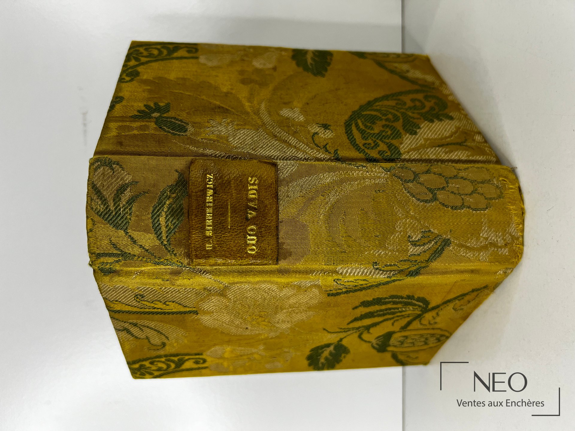 Couverture en tissu fleuri doré avec étiquette de titre au centre