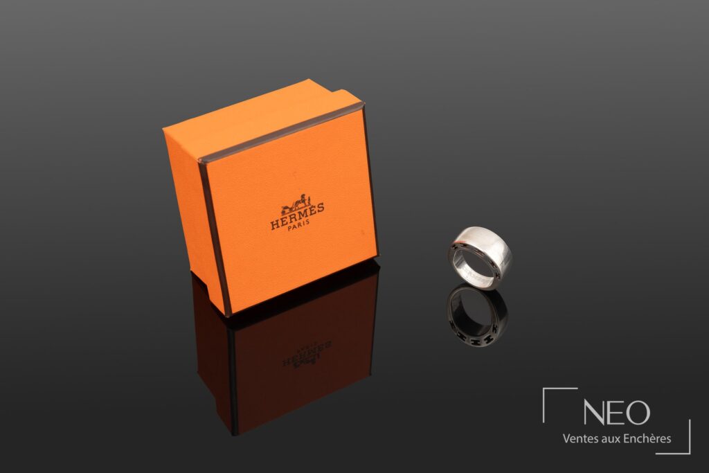 Bague Hermès en argent avec boîte orange siglée à côté