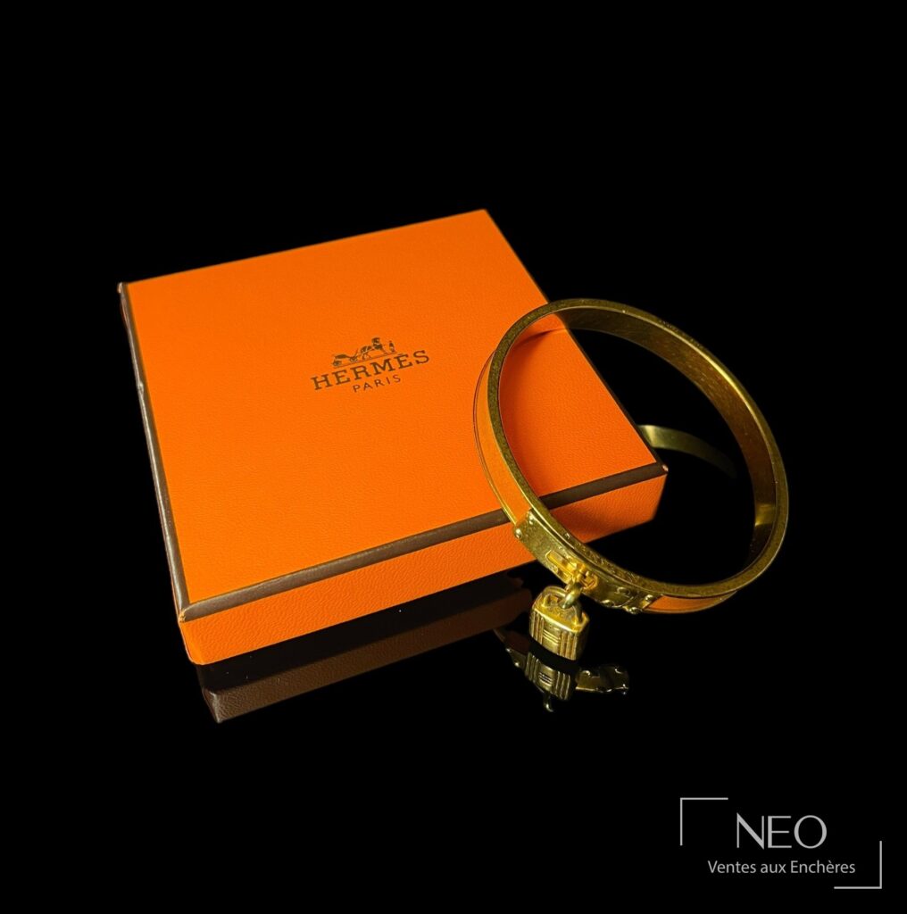 Bracelet Hermès Cadenas Kelly en métal doré et cuir orange
