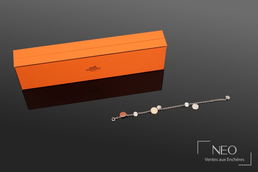 Bracelet Hermès Confettis en argent et or jaune présenté avec son écrin orange