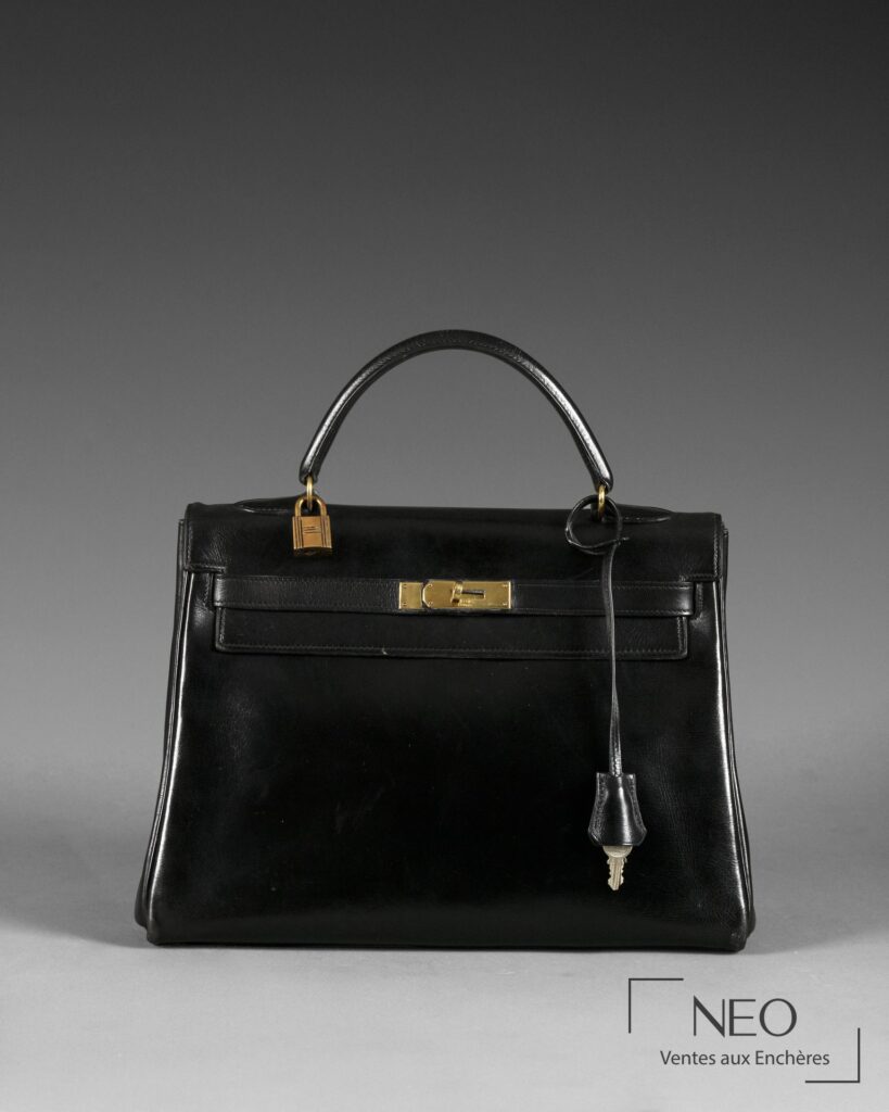 Sac Hermès Kelly 32 noir vu de face avec fermoir doré et clochette.