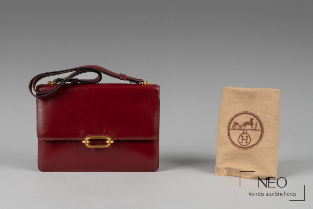 Sac Hermès rouge présenté avec son dustbag beige