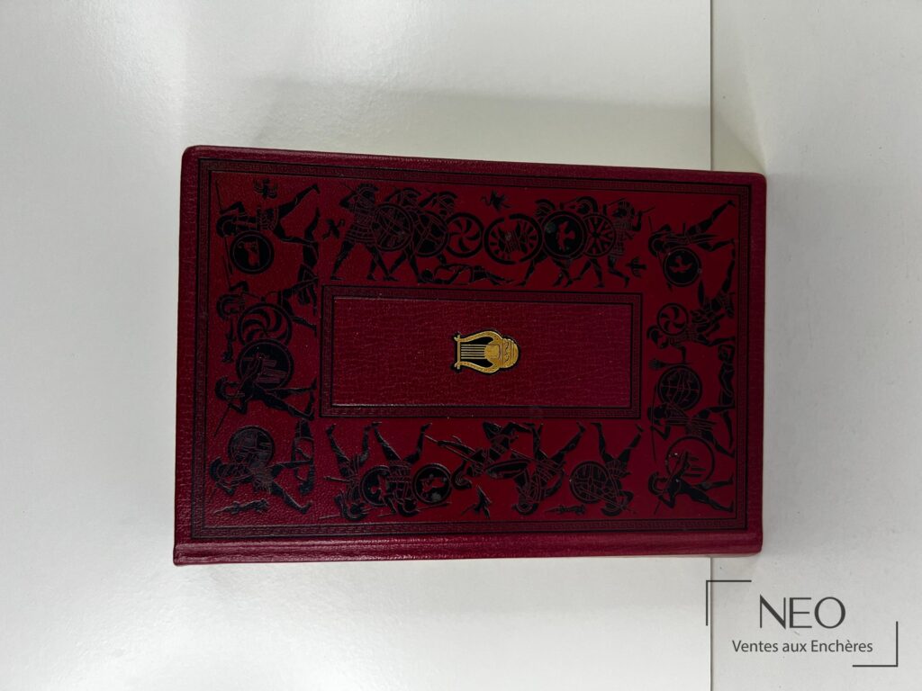 Reliure rouge décorée d une scène guerrière noire avec cartouche central doré