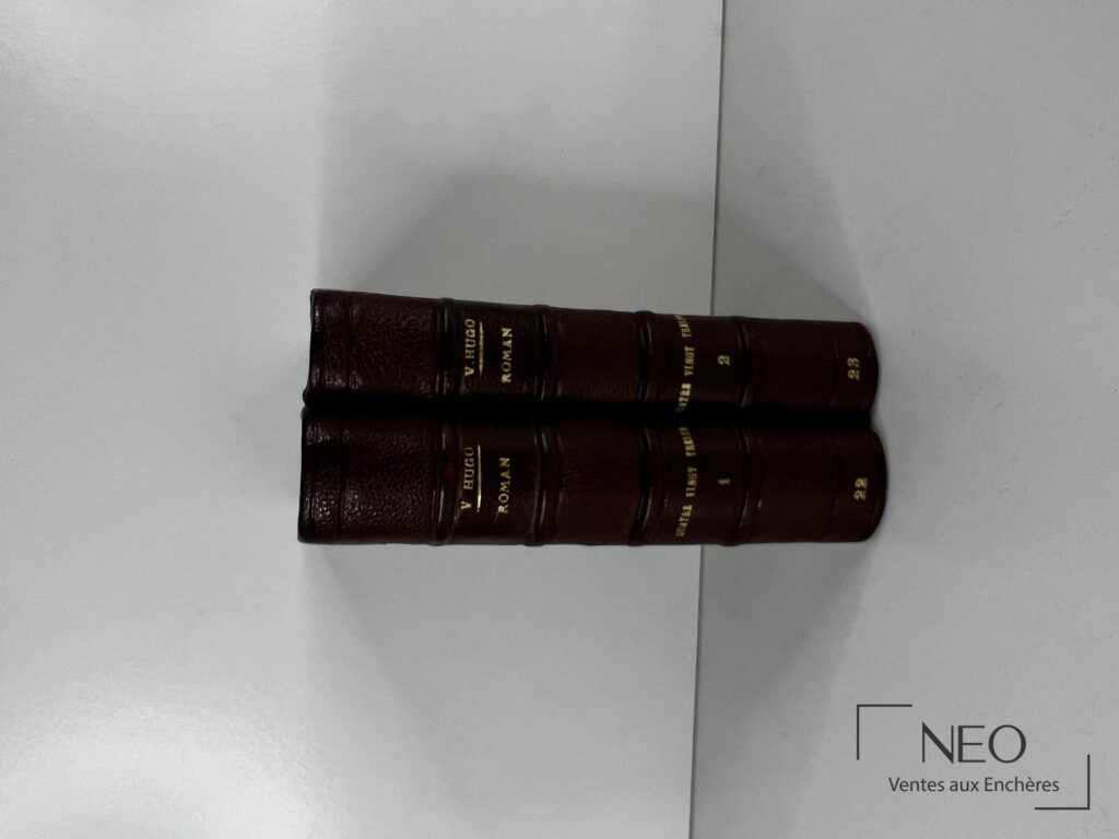 Deux dos de reliures en chagrin brun avec titre doré et nerfs saillants