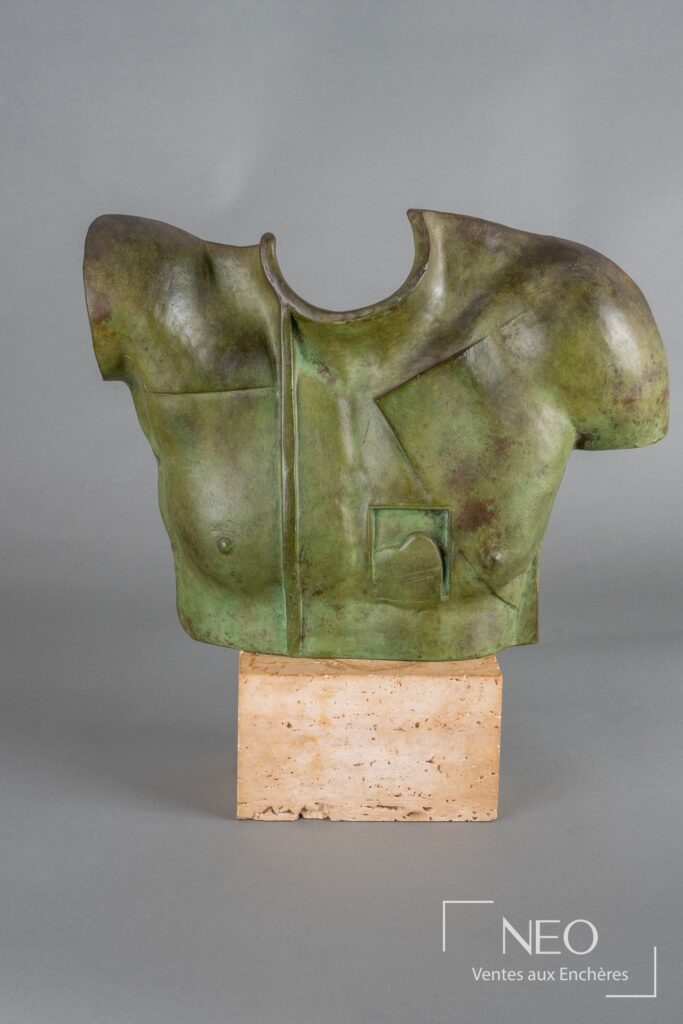 Sculpture en bronze à patine verte posée sur un socle en pierre beige