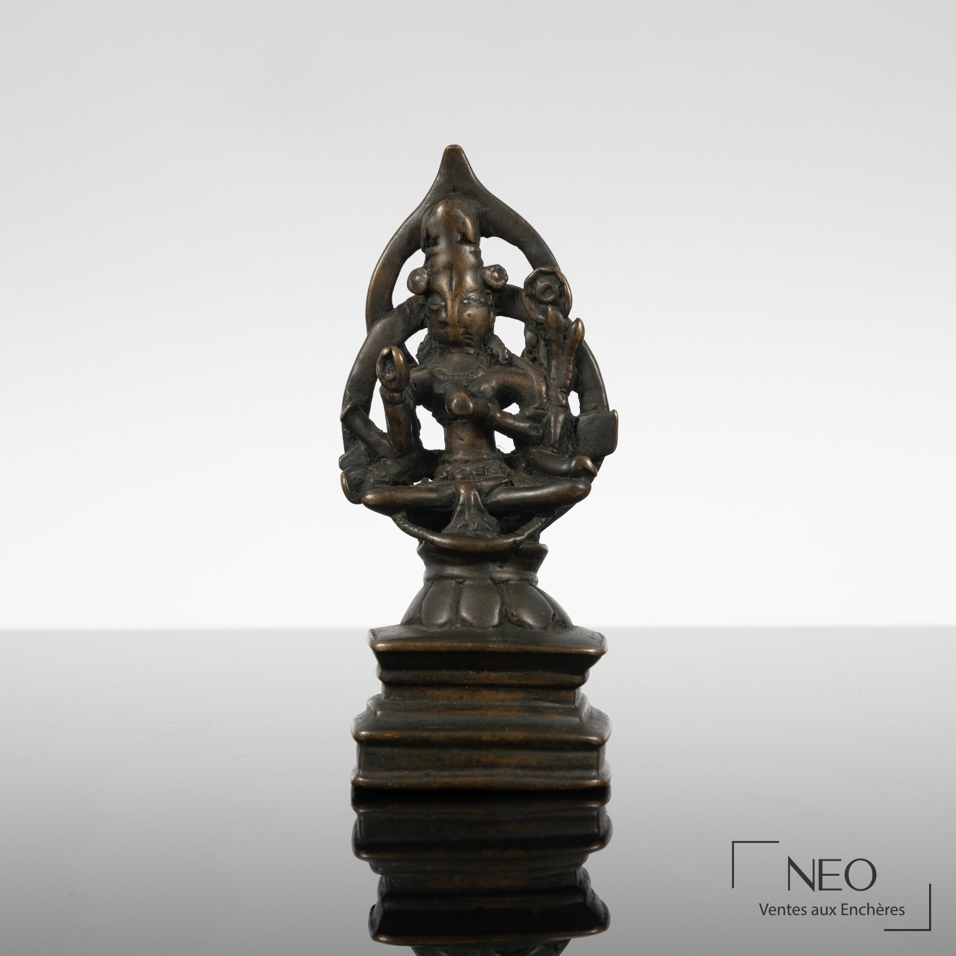 Statuette de divinité assise en bronze à patine brune