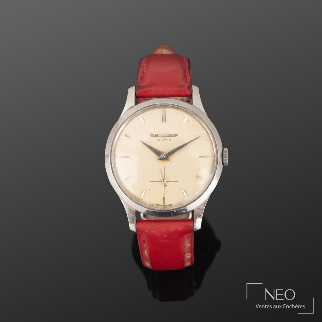 Montre bracelet JAGER-LECOULTRE à cadran argenté et bracelet rouge sur fond gris