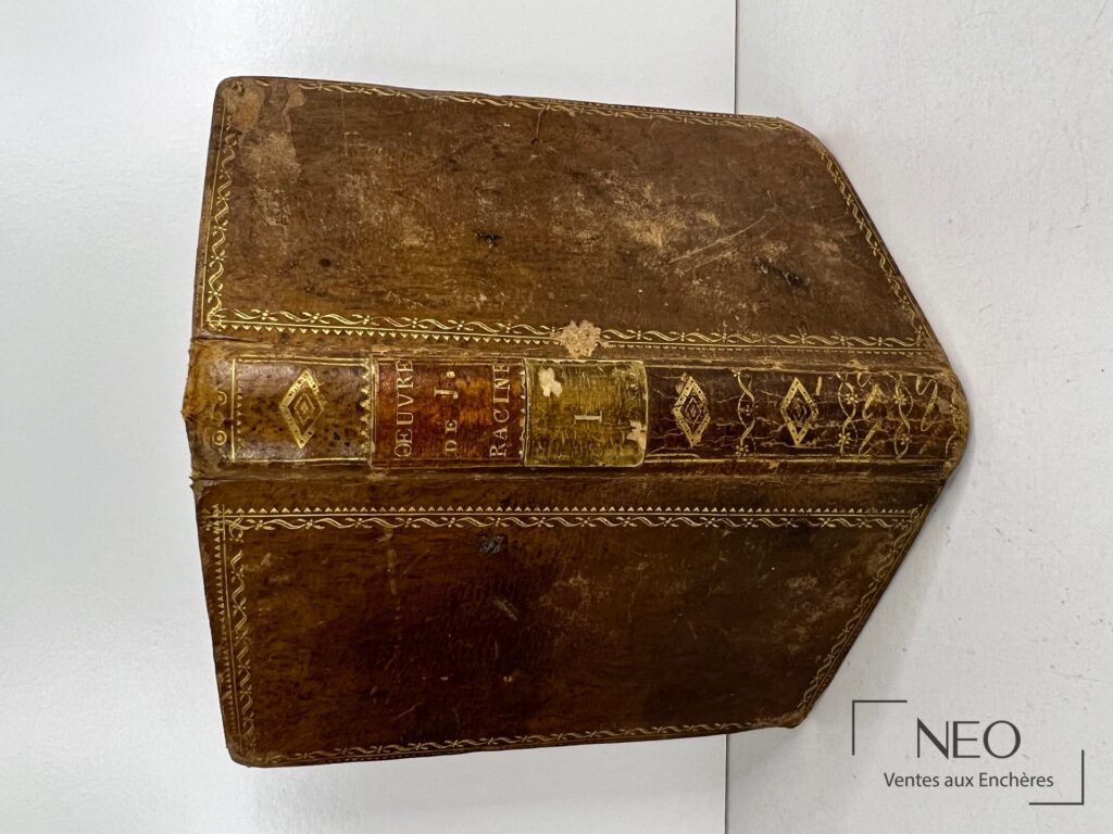 Dos en veau brun orné de dorures avec pièce de titre rouge et traces d'usure