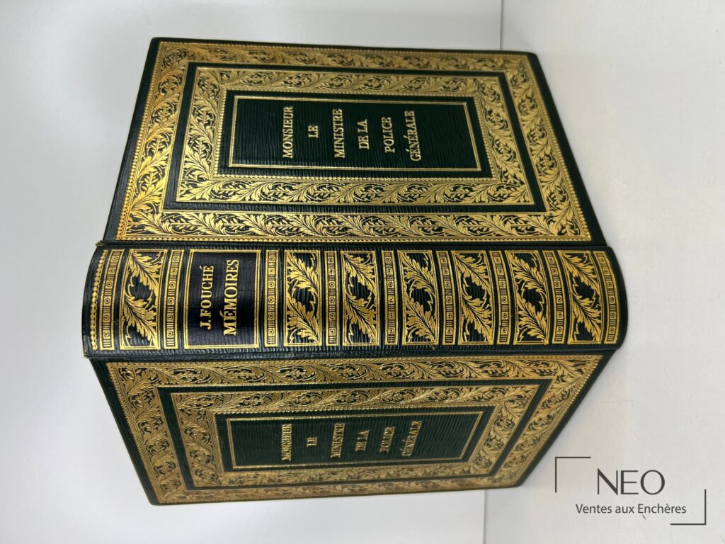 Couverture noire à riches ornements dorés et titre en lettres dorées sur le plat.