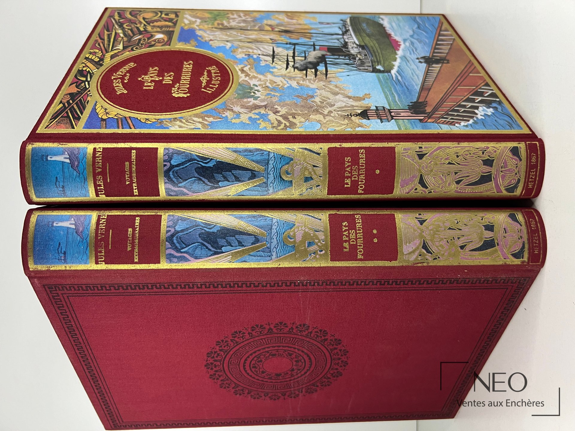 Deux volumes reliés de Jules Verne avec couvertures rouges et polychromes