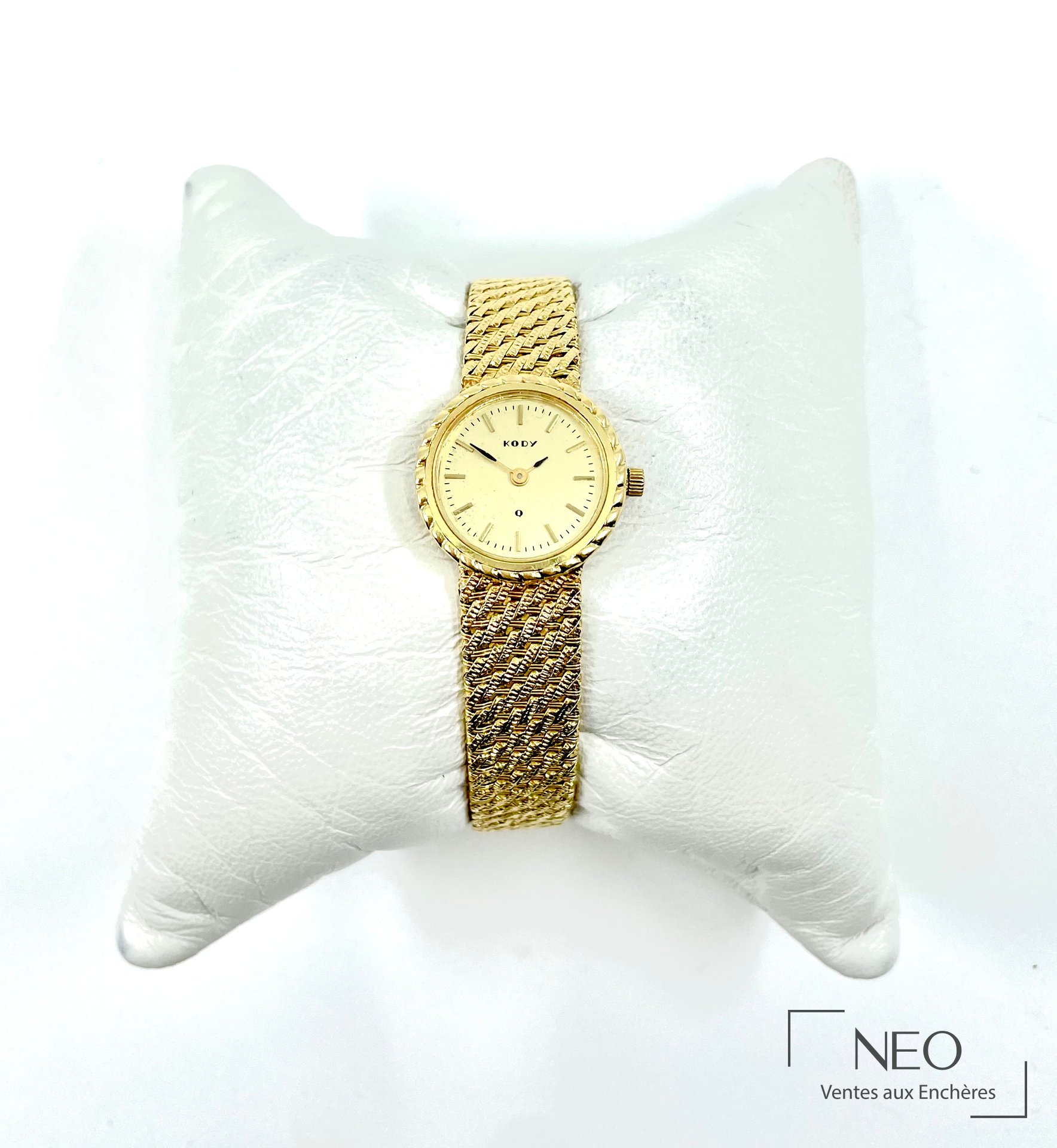 Montre bracelet KODY en or jaune portée sur support blanc