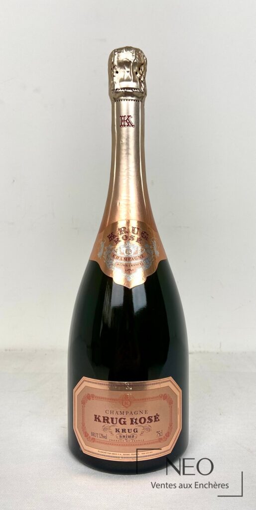 Bouteille de champagne Krug Rosé vue de face avec étiquette rose et coiffe dorée.
