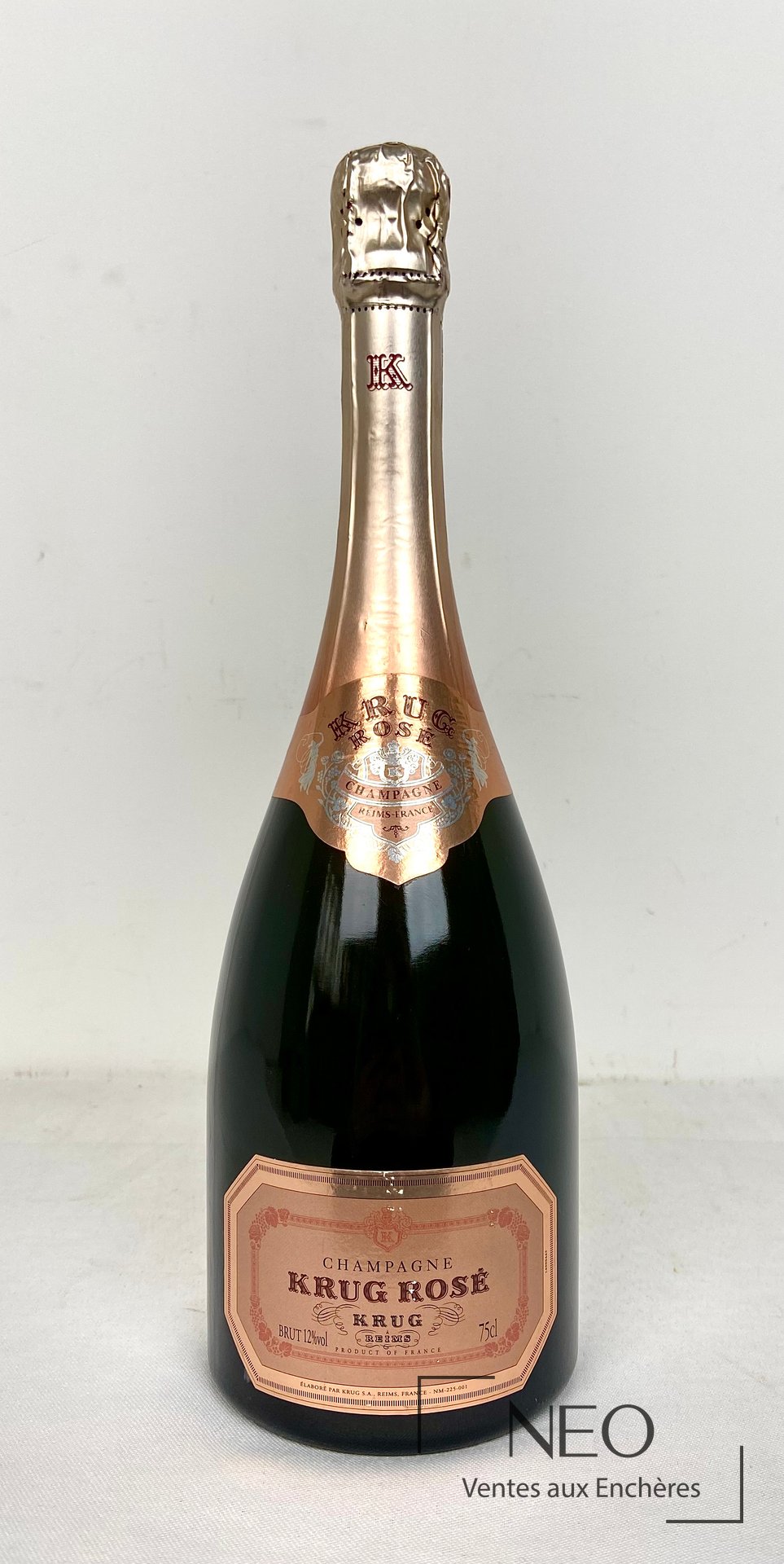 Bouteille de champagne Krug Rosé vue de face avec étiquette rose et coiffe dorée.