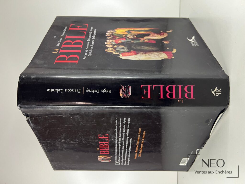 Couverture rigide noire du livre La Bible avec titre rouge et illustration religieuse.