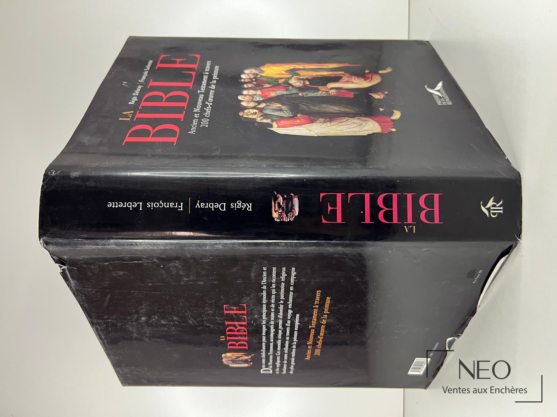 Couverture rigide noire du livre La Bible avec titre rouge et illustration religieuse.