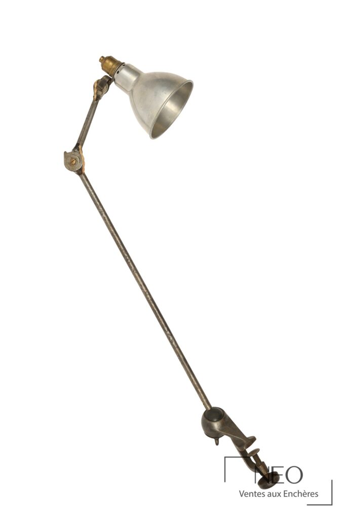 Lampe de bureau en métal à deux bras articulés avec abat-jour conique et étau.