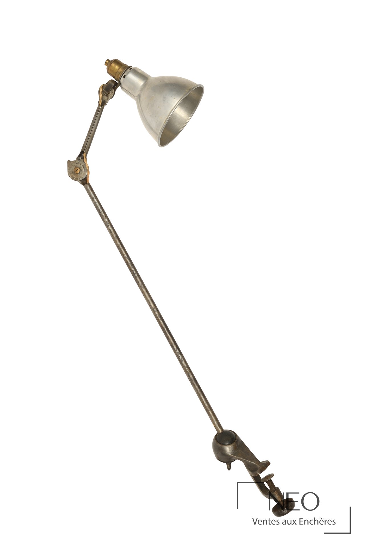 Lampe de bureau en métal à deux bras articulés avec abat-jour conique et étau.