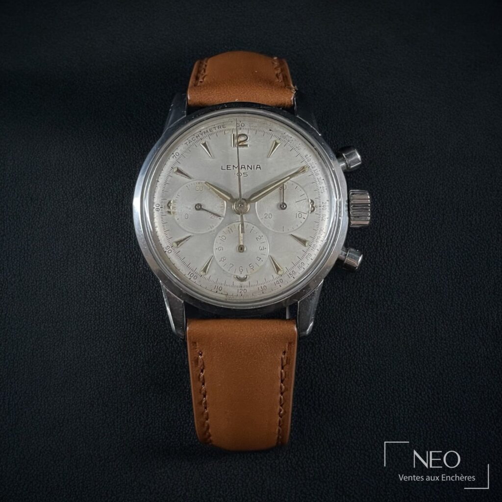 Montre chronographe Lemania 105 en acier avec cadran argenté et bracelet brun.