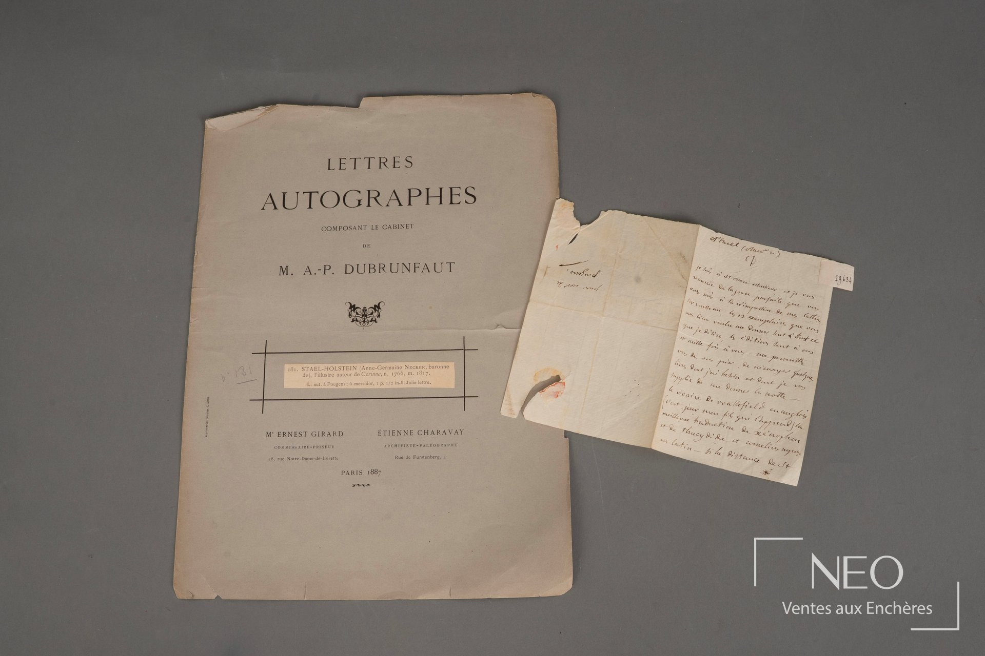 Couverture de catalogue et lettre autographe manuscrite posées sur fond gris